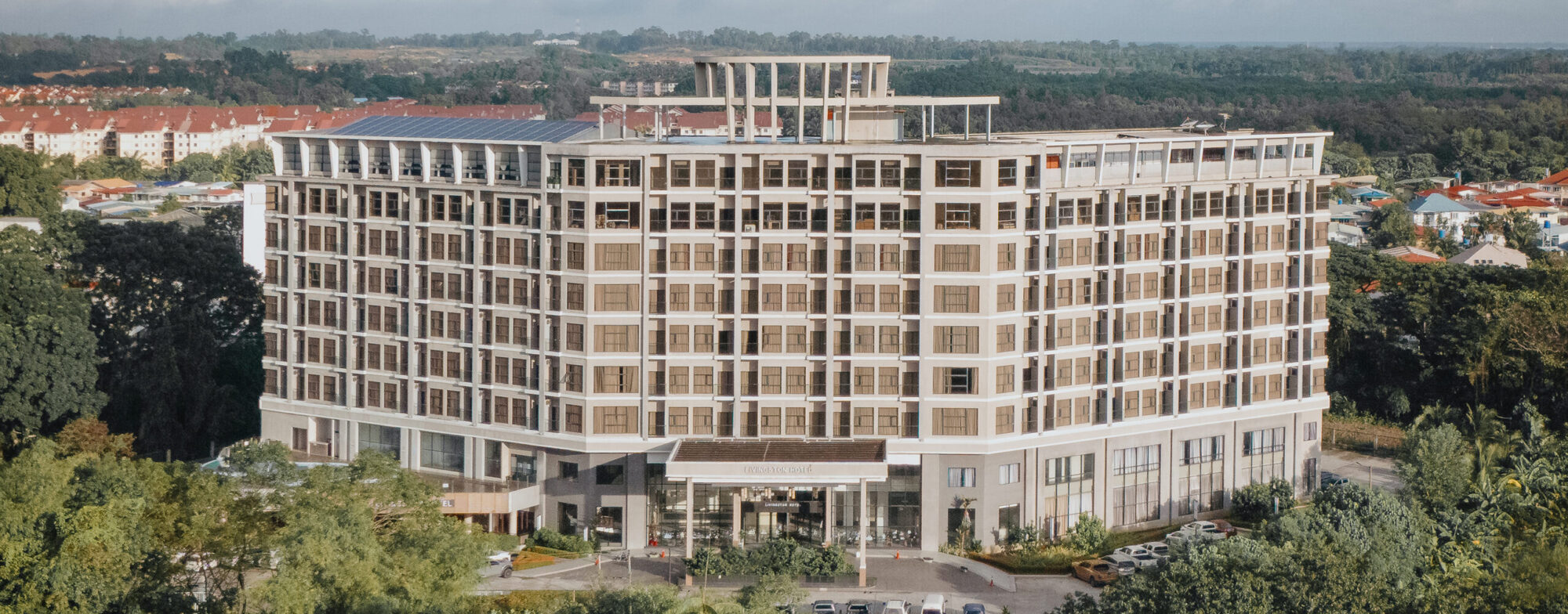 Aerial drone view of Livingston Hotel Sandakan, showcasing the full hotel facade and surroundings
