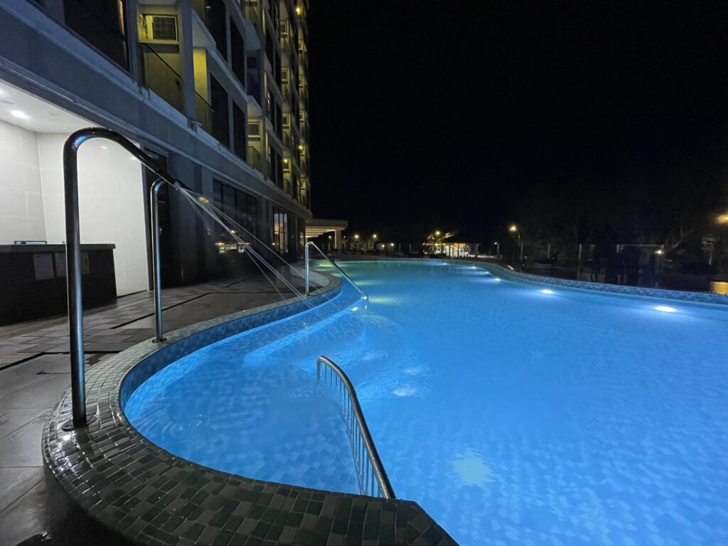 Night view of swimming pool at Livingston Hotel Sandakan showing hotel facade and function hall