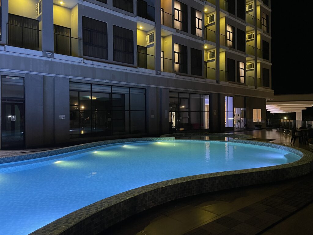 Night view of swimming pool at Livingston Hotel Sandakan with water spray feature