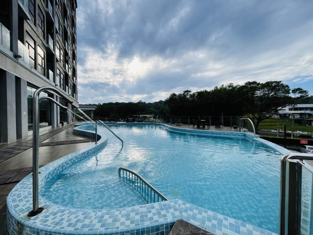 Swimming pool with water spray feature at Livingston Hotel Sandakan under blue sky