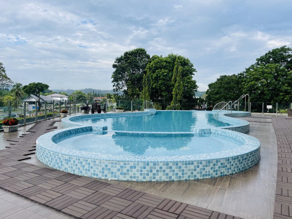 Infinity swimming pool at Livingston Hotel Sandakan with scenic view and surrounding trees