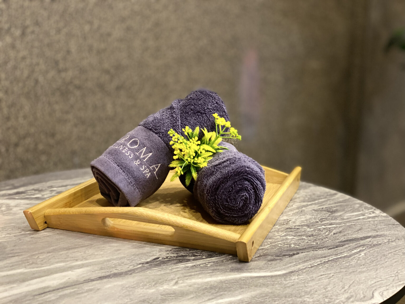 Close-up of Aroma Wellness & Spa branded towel with flower on tray at Livingston Hotel Sandakan