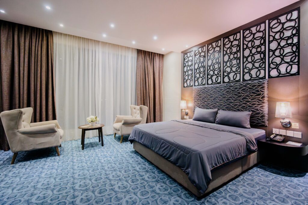 Interior view of Executive Suite at Livingston Hotel Sandakan showing bed, sofa, balcony, and modern luxurious decor