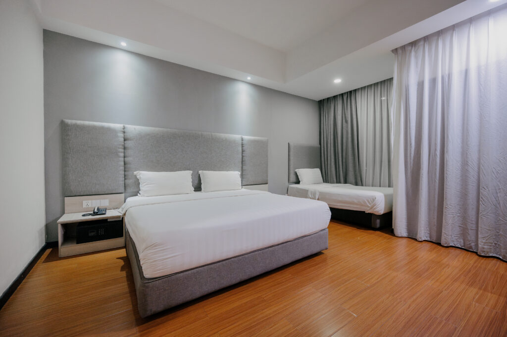 Interior of Deluxe Junior Room at Livingston Hotel Sandakan showing king and single bed with TV
