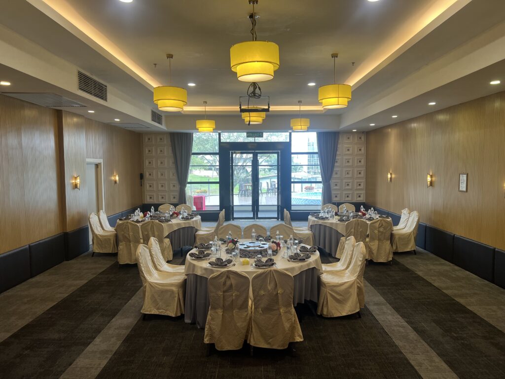 Hotel function room with partial swimming pool view through large windows, modern event space