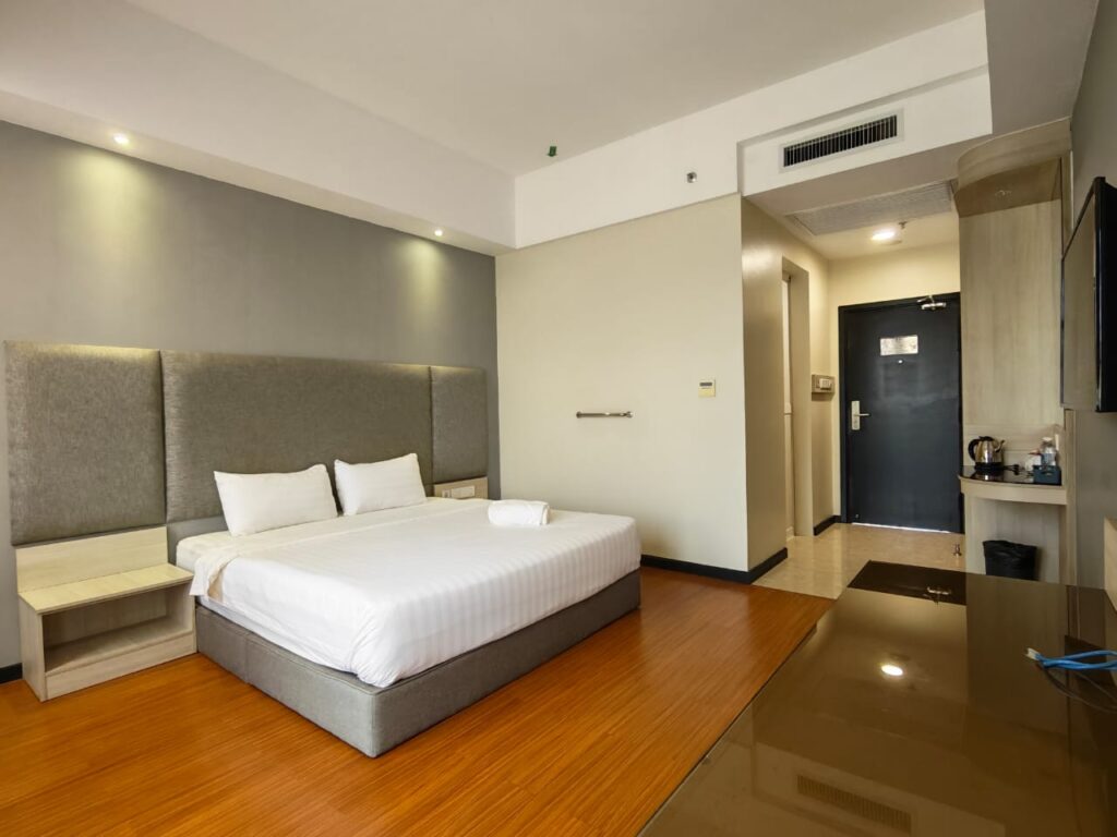 Wheelchair-friendly Accessible Room with bed, TV, sliding door, and grab bar at Livingston Hotel Sandakan Sabah