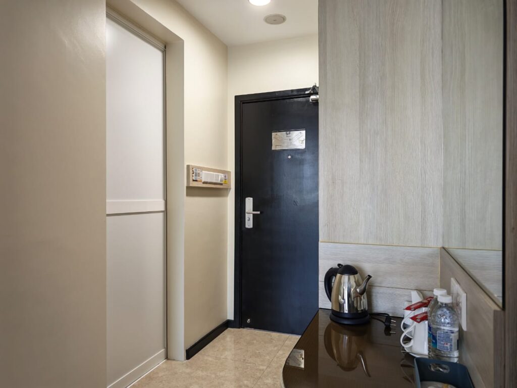 Accessible room with sliding bathroom door, wardrobe, mirror, and in-room coffee and tea amenities at Livingston Hotel Sandakan Sabah